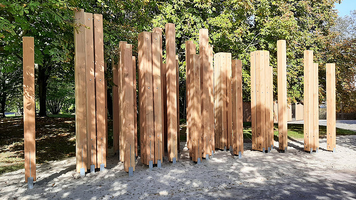 58 Holzstehlen angeordnet zu einem Baumstammlabyrinth