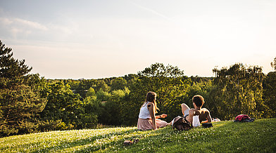 Ein Pärchen entspannt auf einem Hügel im Britzer Garten