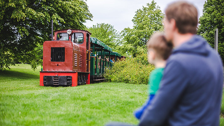 Vater mit Kind vor der Parkbahn im Britzer Garten